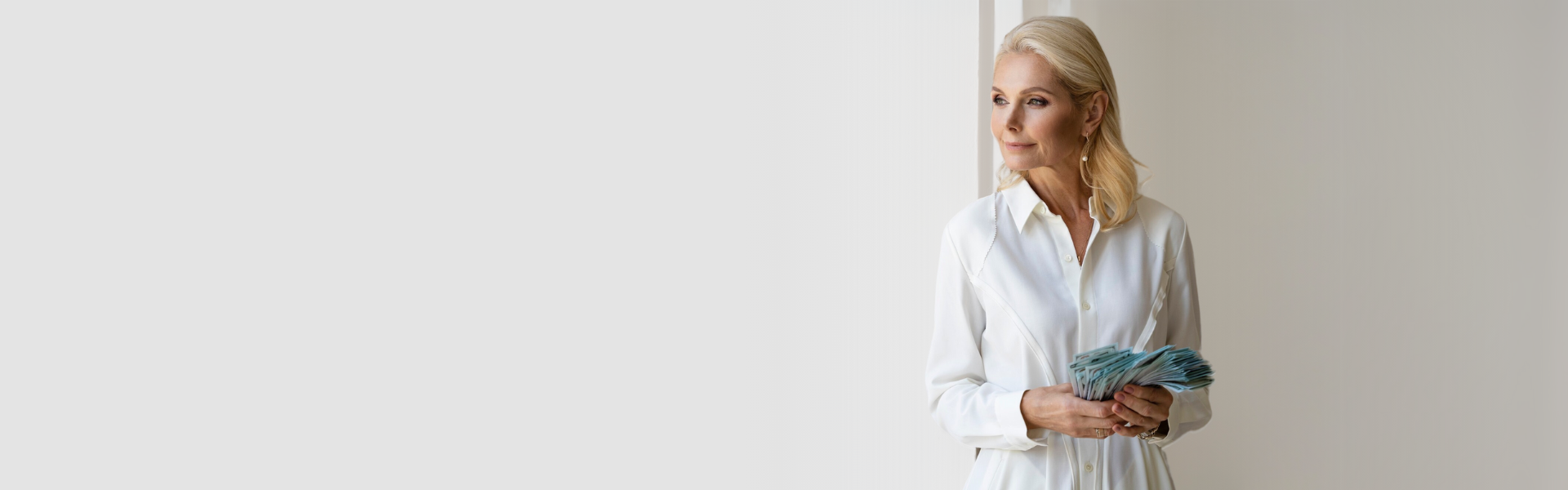Woman in a white shirt holding a fan of banknotes