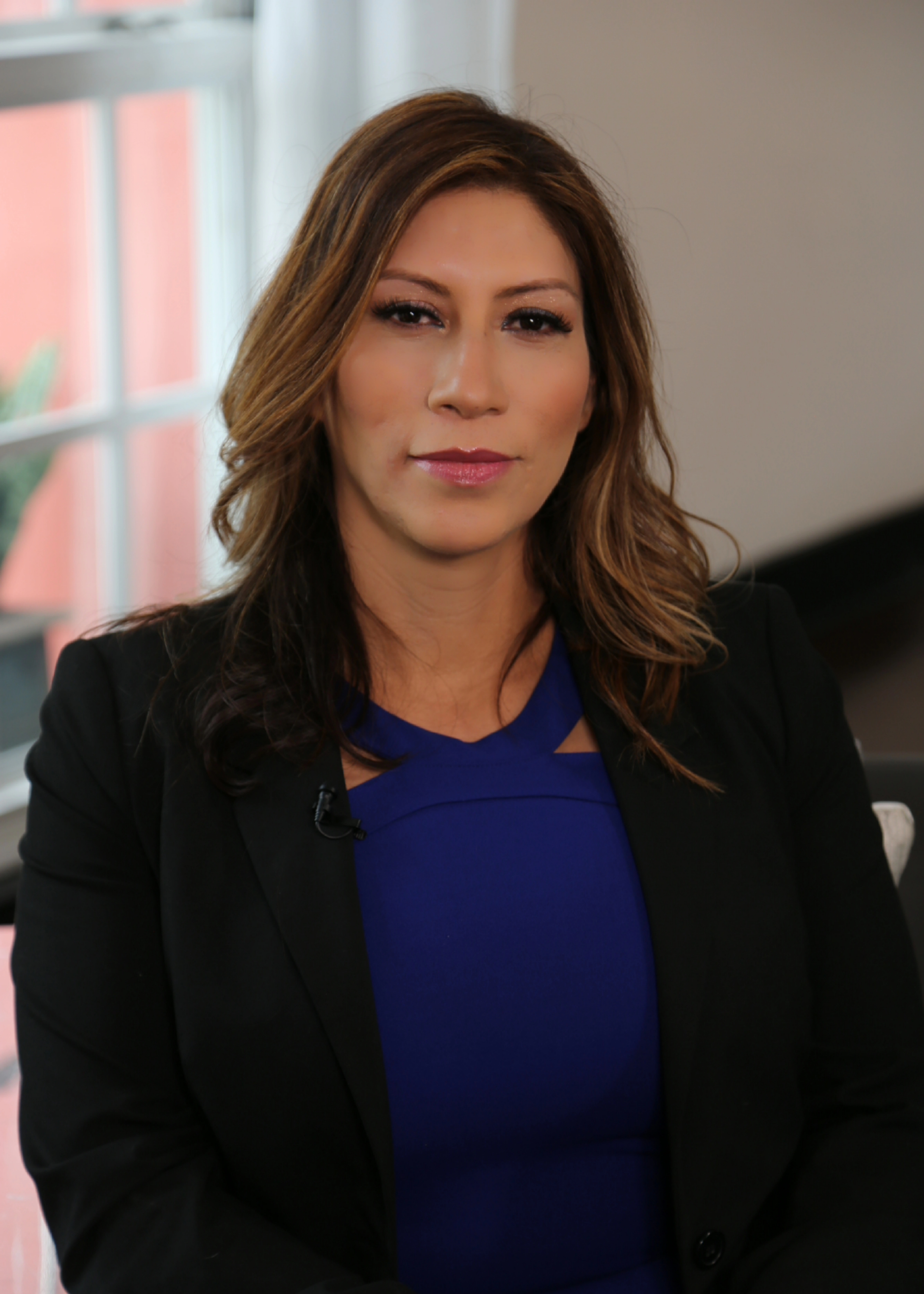 Close portrait of Maria Martinez in a black blazer and blue top
